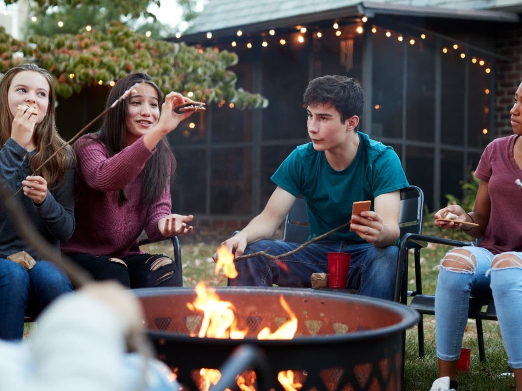 A cozy backyard fire pit surrounded by friends and family in Danville.
